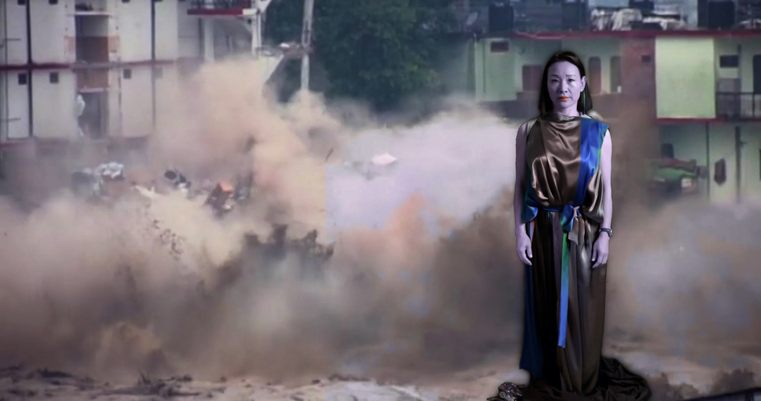 A digital oracle foregrounds a video of a collapsing building a contemporary new media artwork by humans, cyborgs, and the AI revolution.