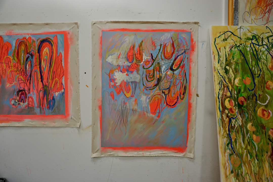 Colorful paintings by Kaitlyn Tucek, tacked to her studio wall.