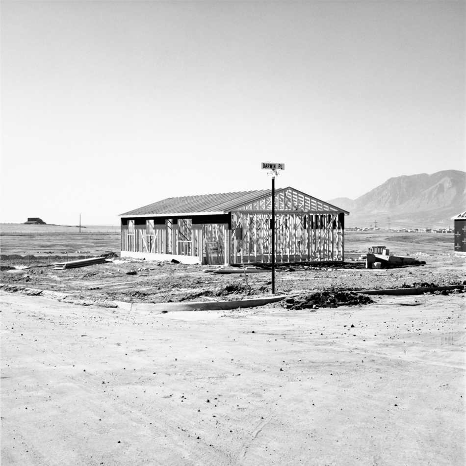 Black and white photo by Robert Adams showing the frame for a tract home in Colorado Springs.