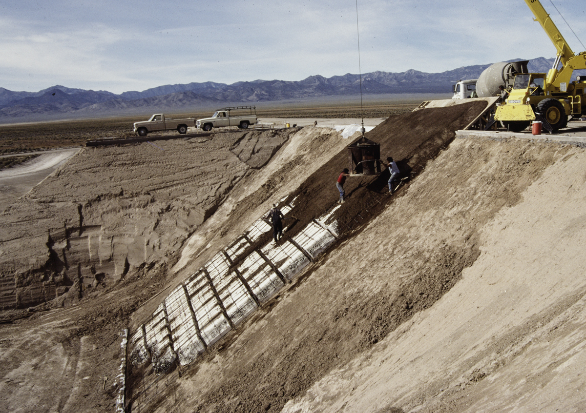Photograph of workers pouring volcanic cinder concrete for Complex Two in Michael Heizer's land artwork, City, in the Nevada desert.