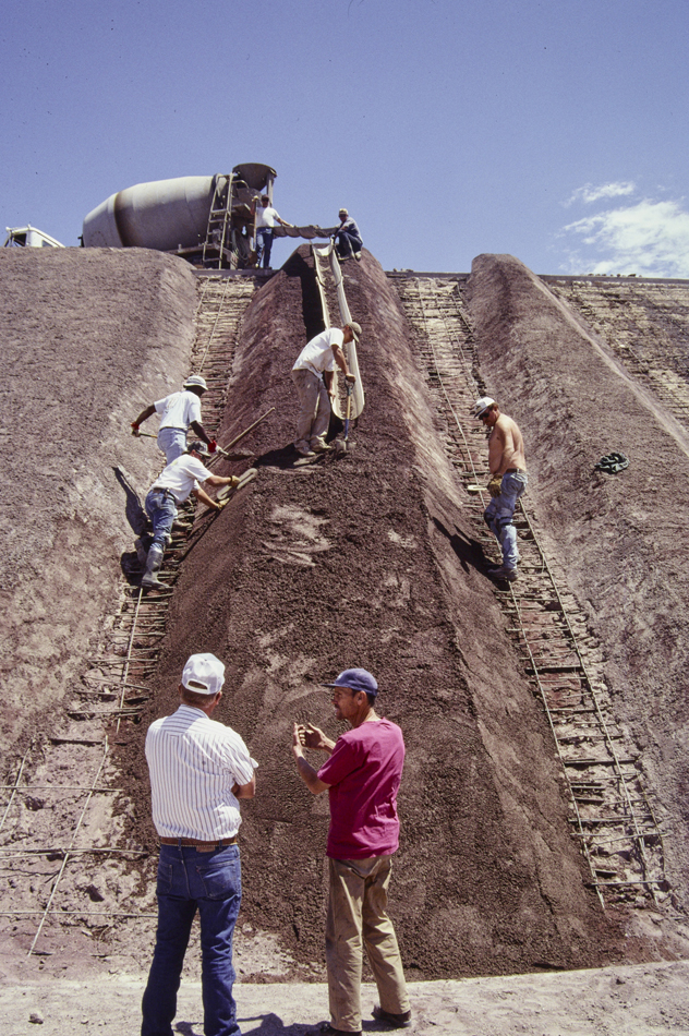 Photograph of workers pouring volcanic cinder concrete for Complex Two in Michael Heizer's land artwork, City, in the Nevada desert.