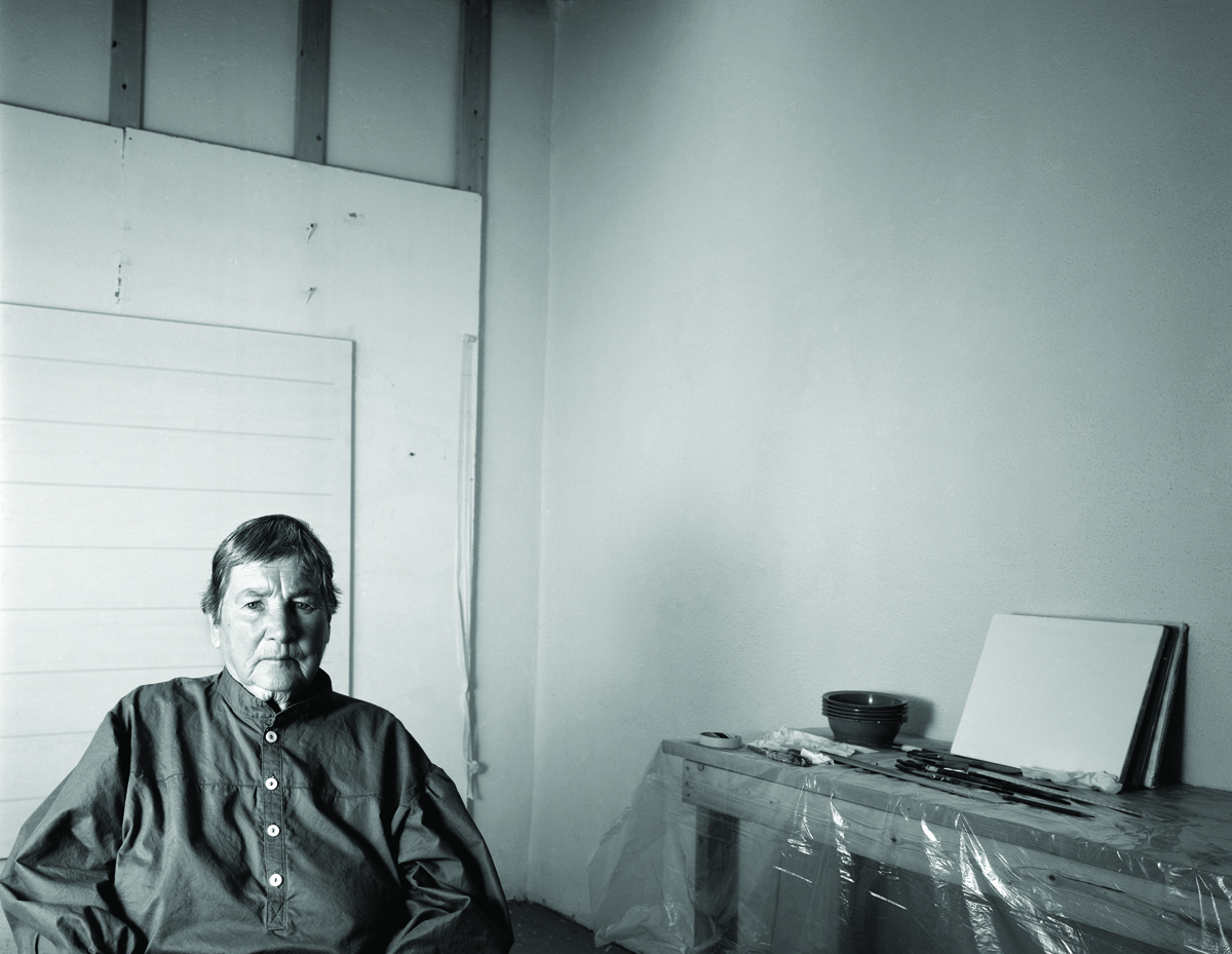 A late-in-life photo of painter Agnes Martin, set back in the frame.