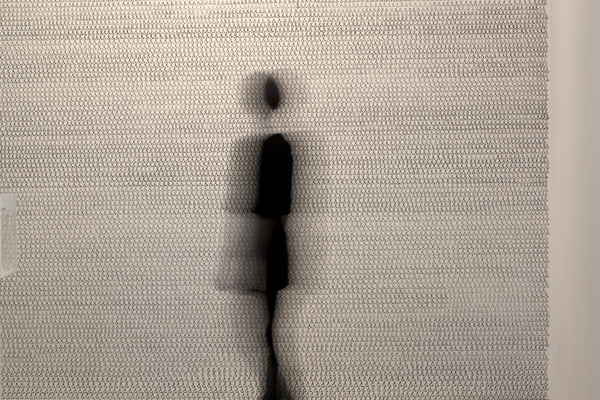 Installation-view photograph of Denver-based artist Joel Swanson's mural titled Ampersand, with a blurred silhouette of a person walking in front of the mural for scale.