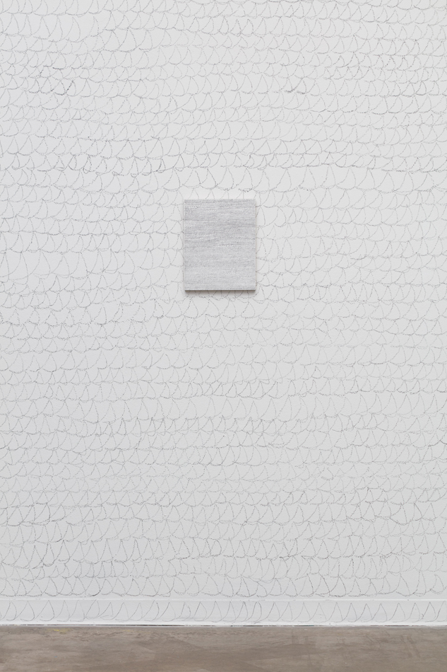 Photo of Denver-based artist Joel Swanson's graphite artwork, Cursive Lisp, hanging on top of his graphite mural with the same title. 
