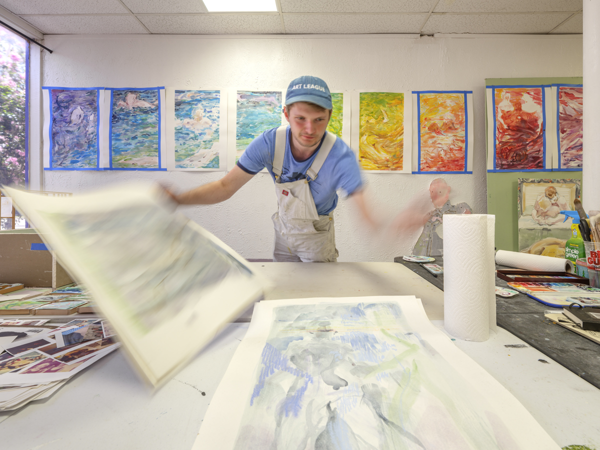 Eli Ruhala examines works on paper in his Dallas studio.