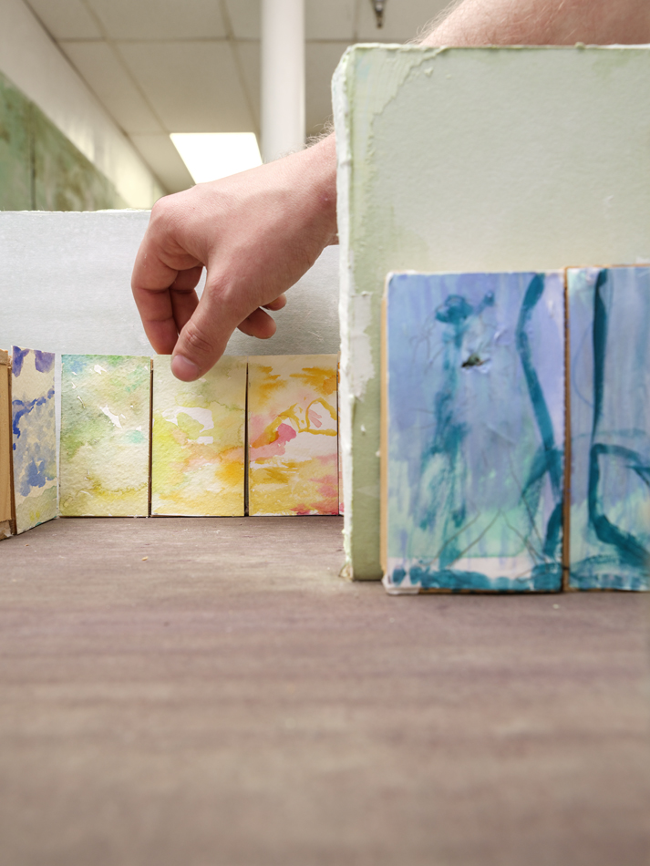 Eli Ruhala arranges a maquette for a large-scale painting exhibition.