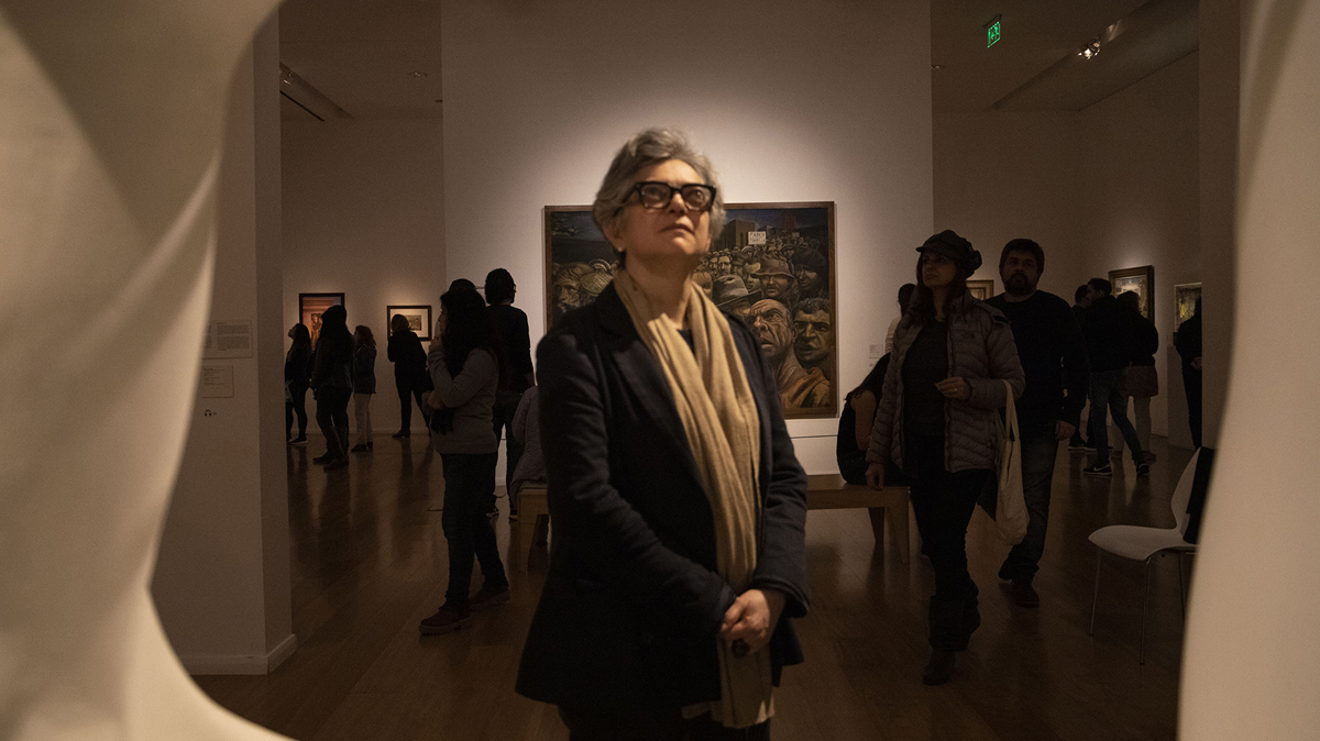 Portrait of curator Gabriela Rangel looking at art.