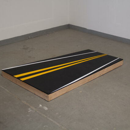 Photo of an artwork by Albuquerque-based artist Justine Kablack, showing a visual of an asphalt highway painted onto pine and plywood.
