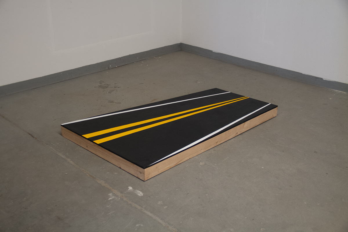 Photo of an artwork by Albuquerque-based artist Justine Kablack, showing a visual of an asphalt highway painted onto pine and plywood.