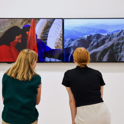Two museum visitors view a video work by Marina Abramović / Ulay in Step After Step at Kimball Art Center.