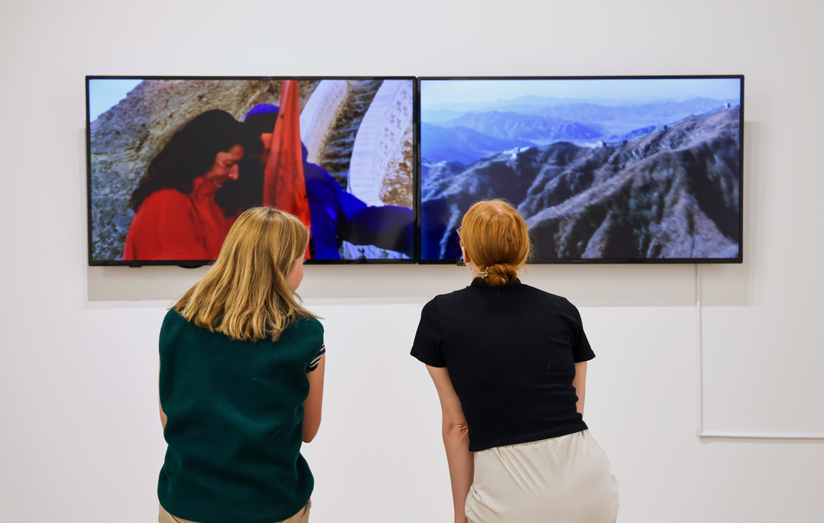 Two museum visitors view a video work by Marina Abramović / Ulay in Step After Step at Kimball Art Center.