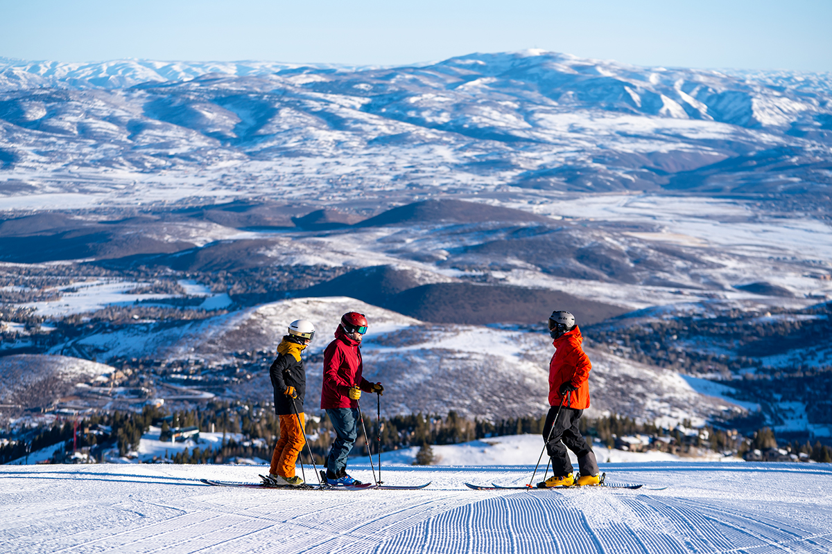 Skiers in Park City, Utah, survey the snowy mountain landscape.