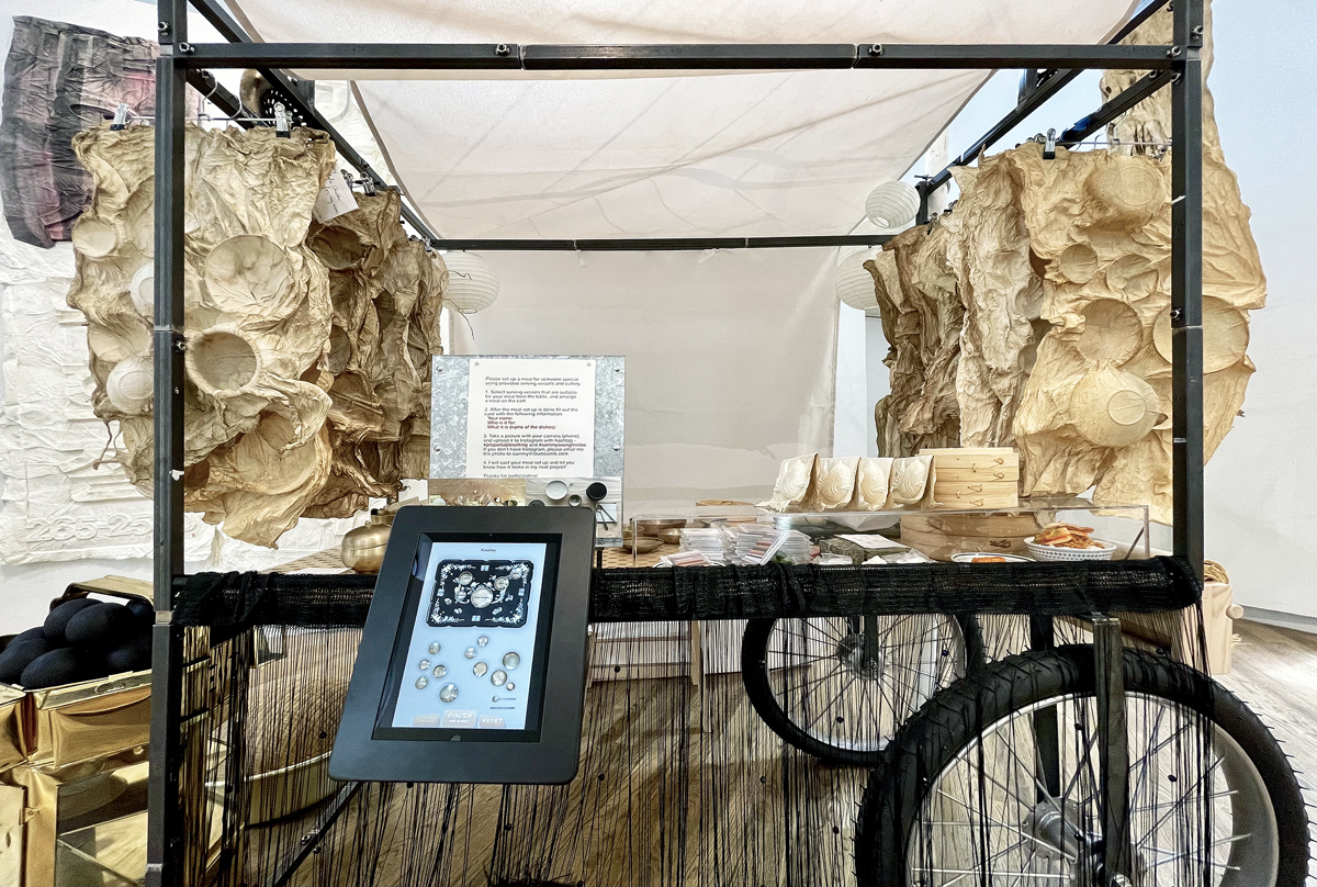 A cart filled with sculptures made from paper by Sammy Lee.