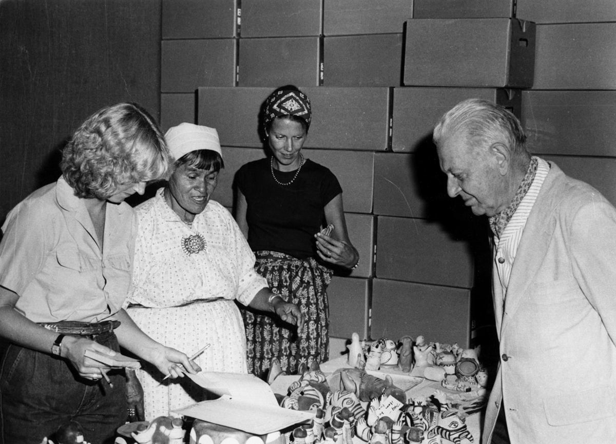 Helen Cordero looks at Cochiti Pueblo pottery with Alexander Girard, Charlene Cerny, and Barbara Babcock at Museum of International Folk Art.
