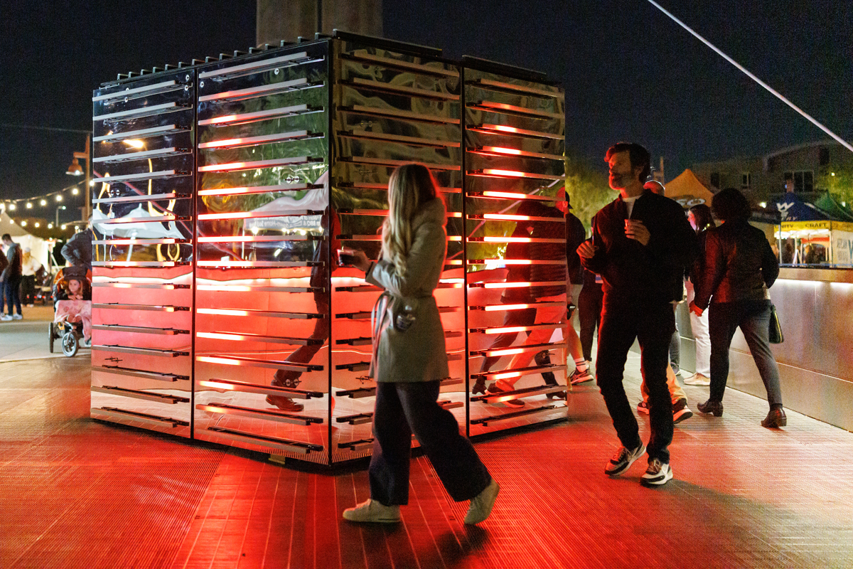 Festival goers encircle a glowing cube at Canal Convergence in Scottsdale, Arizona, an essential stop in our winter Arizona Art Guide.