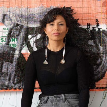 Gloria Martinez- Granados in front of the textile work Braceros: Can 48,900 stitches hold history?(2023).