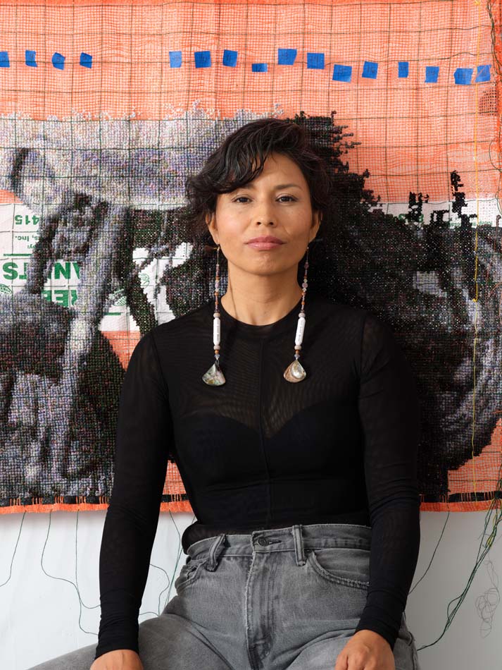Gloria Martinez- Granados in front of the textile work <i>Braceros: Can 48,900 stitches hold history?</i>(2023).