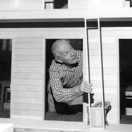 Designer Alexander Girard inside a miniature house, part of his Museum of International Folk Art exhibition in Santa Fe.
