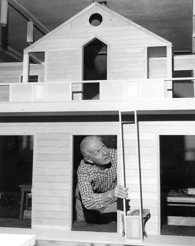 Designer Alexander Girard inside a miniature house, part of his Museum of International Folk Art exhibition in Santa Fe.