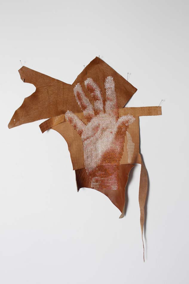 Cross-stitch hand on a piece of leather.