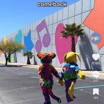 TikTok screenshot from the official @lisafrank account, with two mascots, hand in hand, skipping in front of the Lisa Frank warehouse with the title "When we casually make a MAJOR comeback".