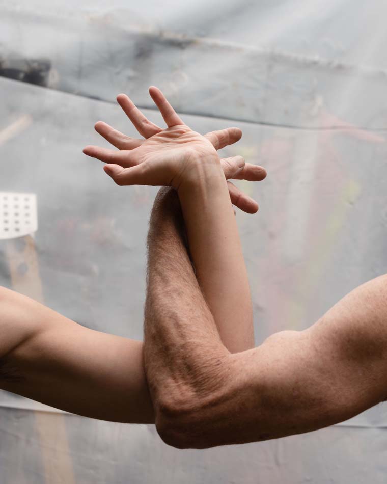 Two arms intertwined and pulling against each other.