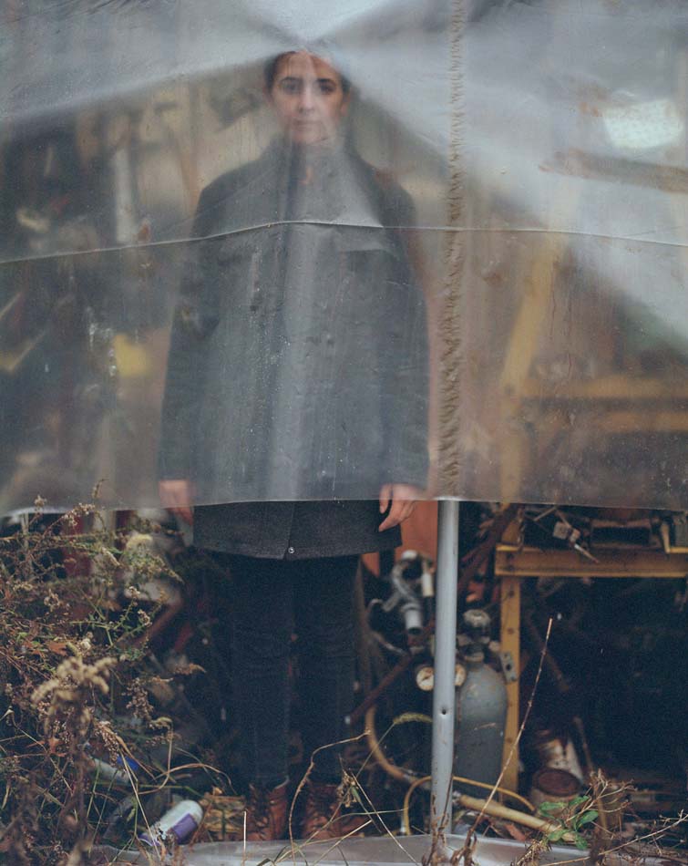 Artist Phoebe Shuman-Goodier standing behind a piece of plastic sheeting.