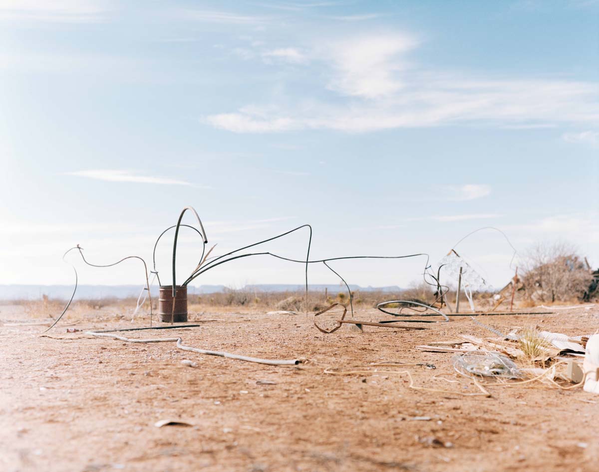 Photograph of West Texas desert horizon with a rusty can and scrap metal.