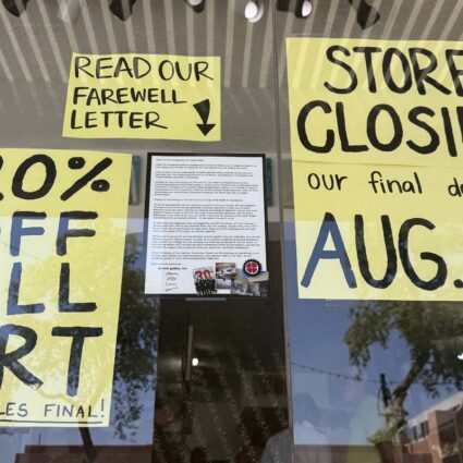 Signs in the window indicating the closure of Art One Gallery in Scottsdale.