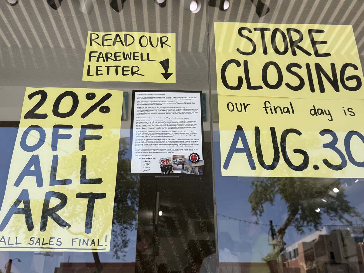 Signs in the window indicating the closure of Art One Gallery in Scottsdale.
