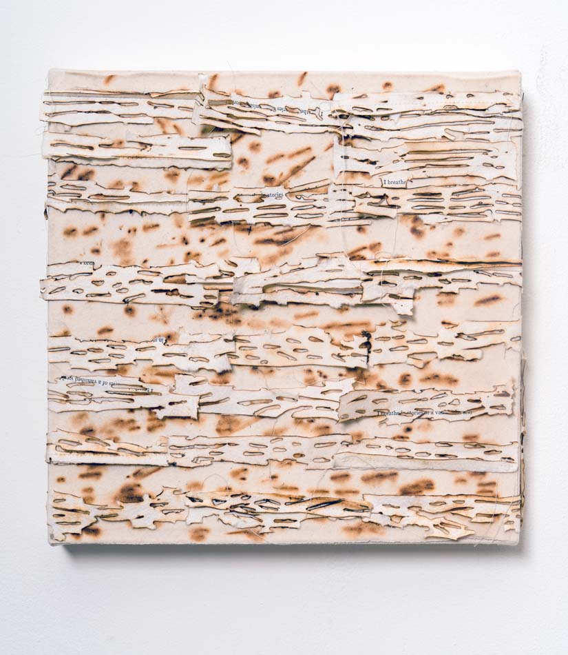 Work by Judy Tuwaletstiwa made of glass and paper that appears to have holes and burn marks all over.