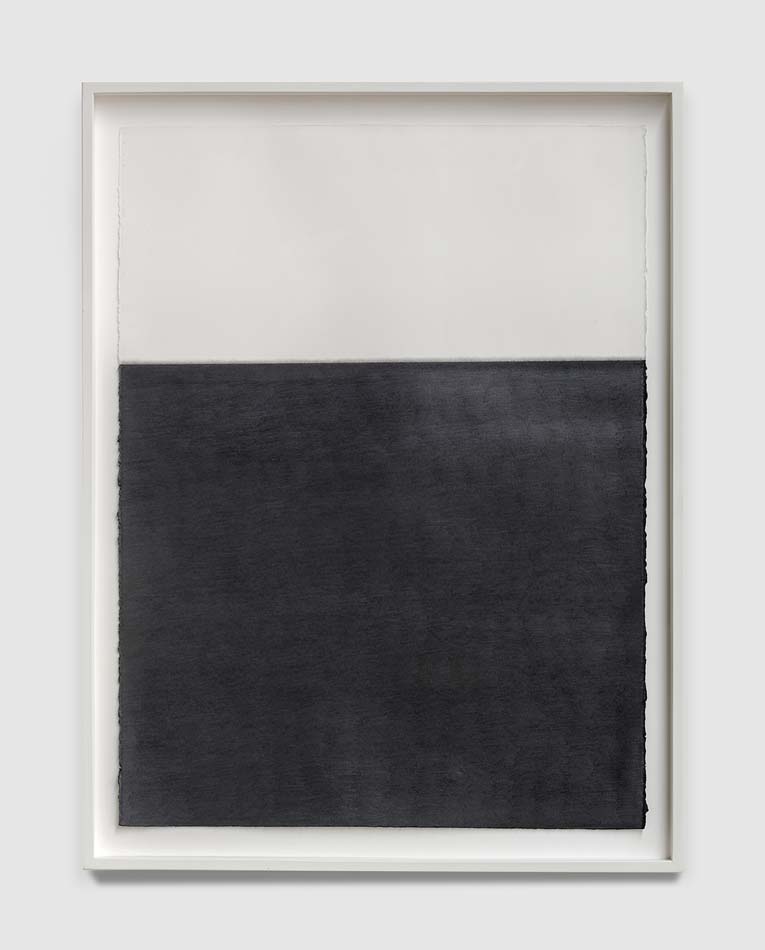 Work by Susan York with a square of dark graphite on the lower part of a sheet of white paper.