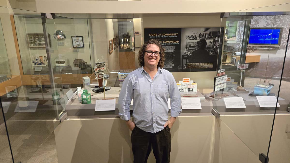 Portrait of Jorge Ruiz in his exhibition Signs of Community: Signage of the Old Pueblo in Miniature in Tucson, Arizona.