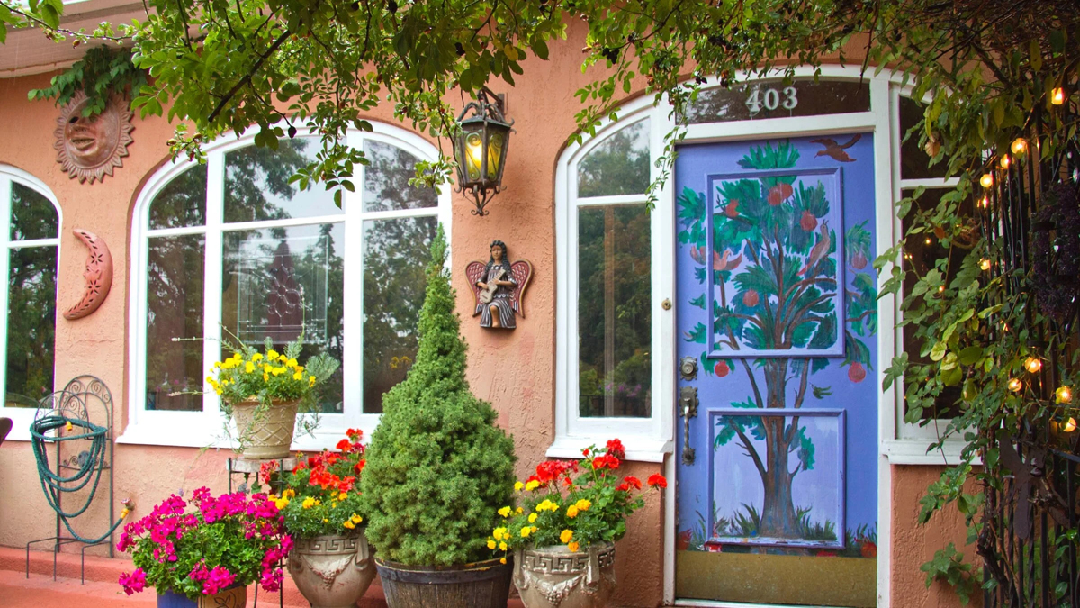 The exterior of Pilar Pobil's home is adorned with murals and encircled with flowers.