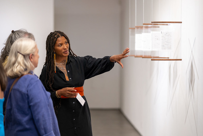 Artist Nikesha Breeze showing someone their art at 516 Arts