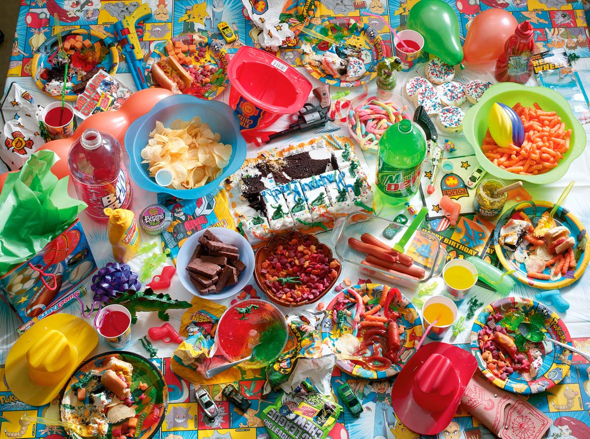 a plastic Pokemon tablecloth is laden with a feast of store-bought snacks and party favors.
