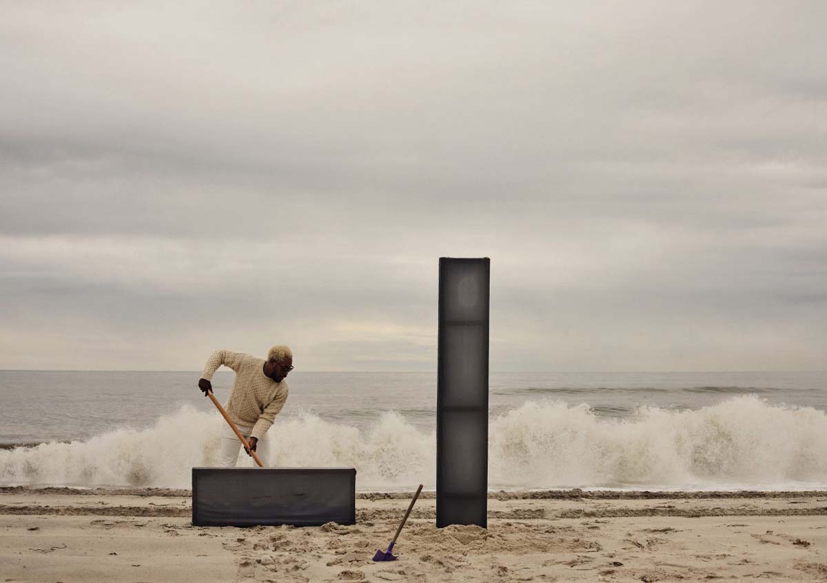 James Perkins at work on Fire Island with two post totems on the sand.