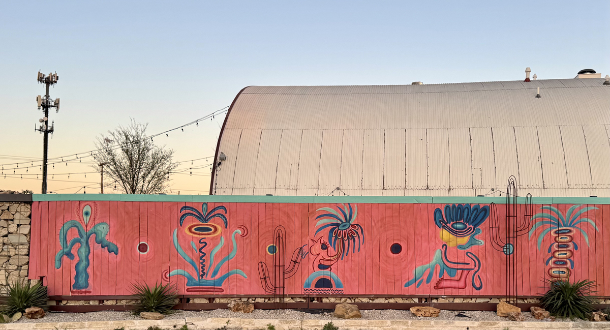 Abstract mural evoking alebrijes, fantastical Mexican folk art creatures, by Mariell Guzman in Dallas. Part of the complete Southwest Mural Guide.