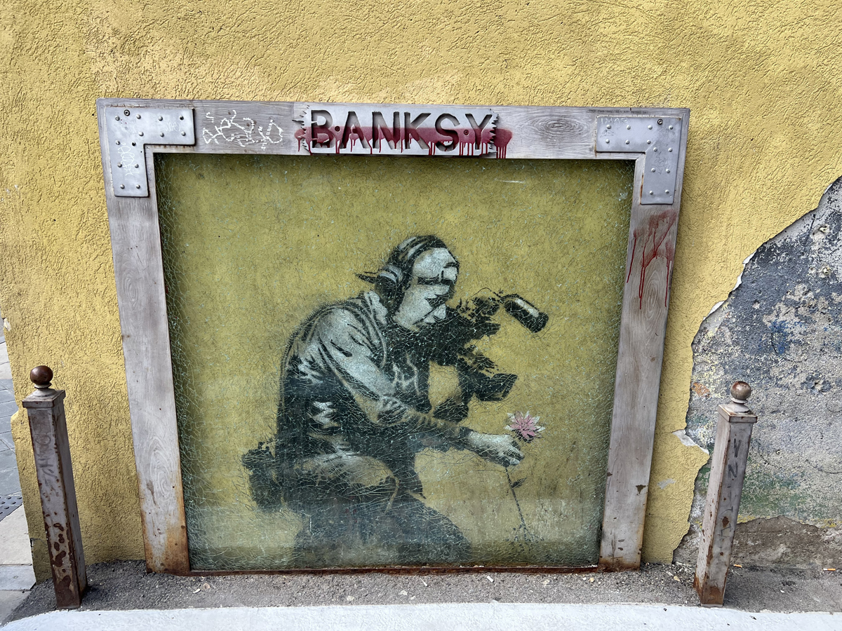 Banksy mural of a cameraman picking a flower in Park City, Utah.
