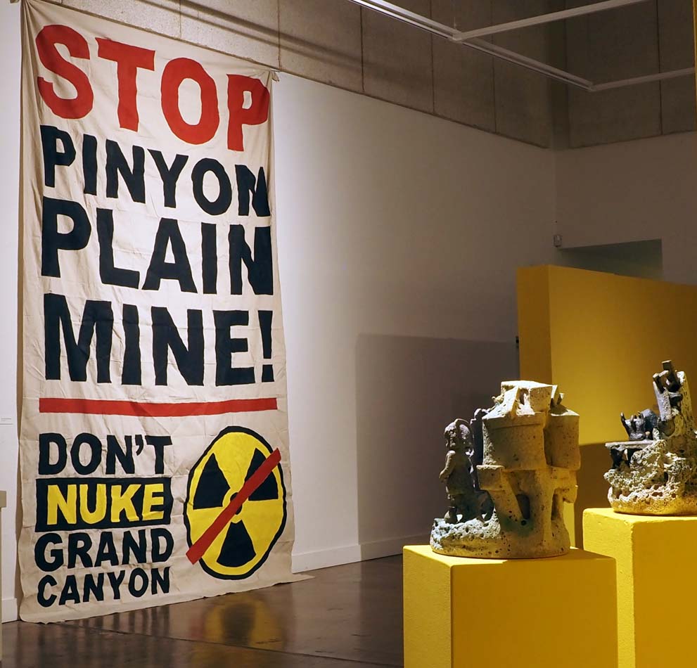 Installation view with large scale activist banner reading Stop Pinyon Plain Mine, Don't Nuke Grand Canyon.