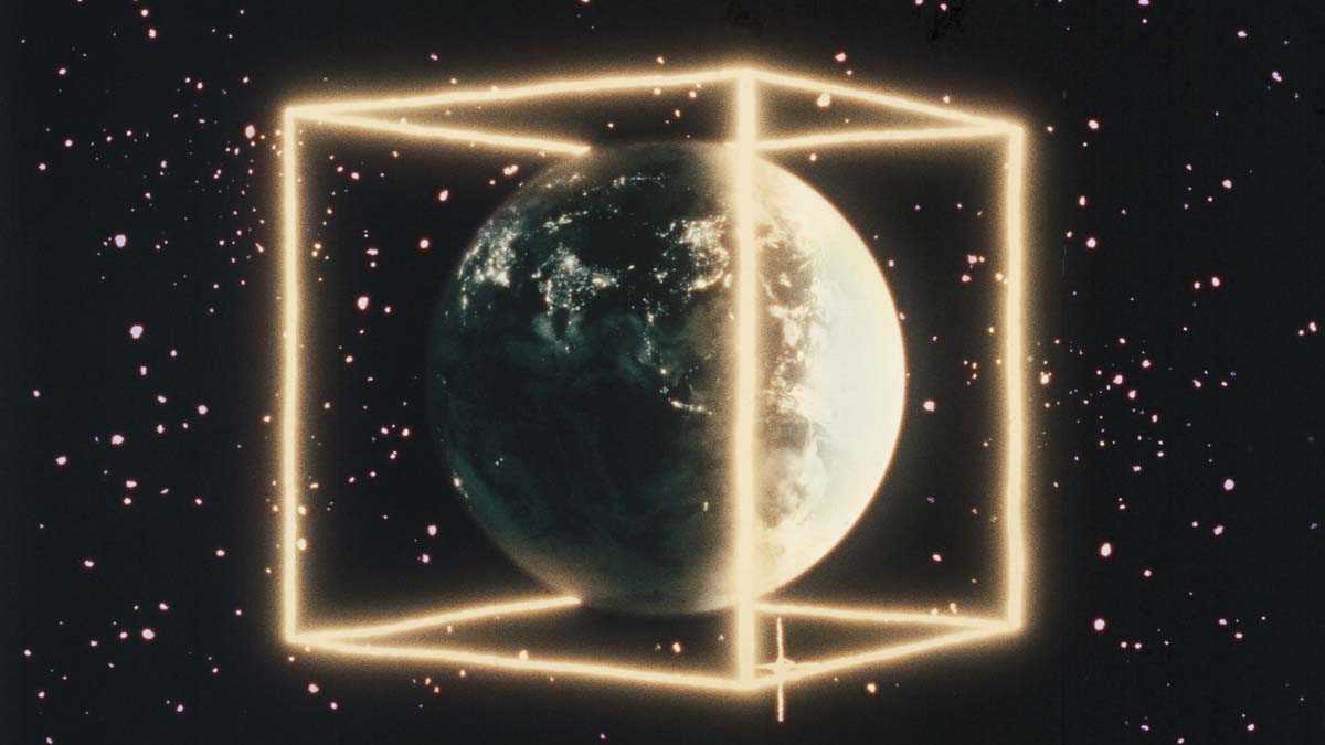 Still from the Godfrey Reggio film Once Within a Time, showing the globe within a glowing outline of a cube.