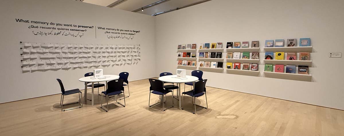Safwat Saleem: The Unrequited Love Institute (T.U.L.I.) installation view, with wall of book shelves and charts.