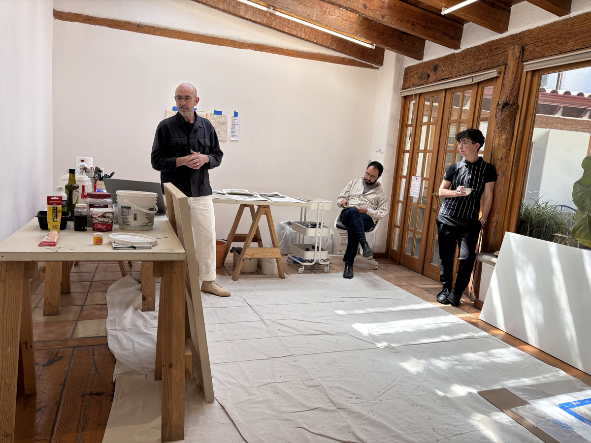 Three artists discuss work in a sunny studio space. The Casa Lü residency is just one of the top Mexico City artist residencies on the ultimate list for visual artists and curators.