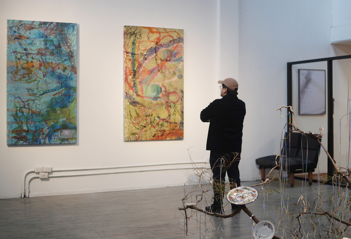 A visitor looks at in-progress paintings during an open studio at an artist residency. The Rondo Residency is just one of the top Mexico City residencies on this comprehensive list for visual artists and curators.