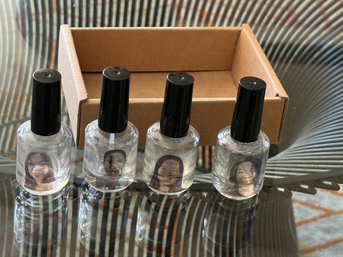 Bottles of nail polish with the faces of nail technicians on them, from a conceptual performance project.