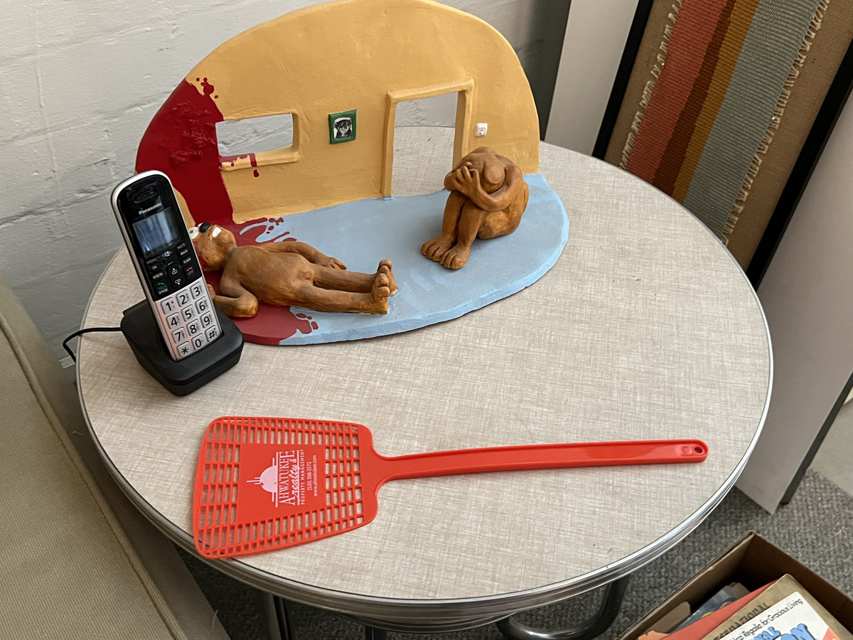 A flyswatter, sculpture, and phone in the studio of artist Ed Mell.