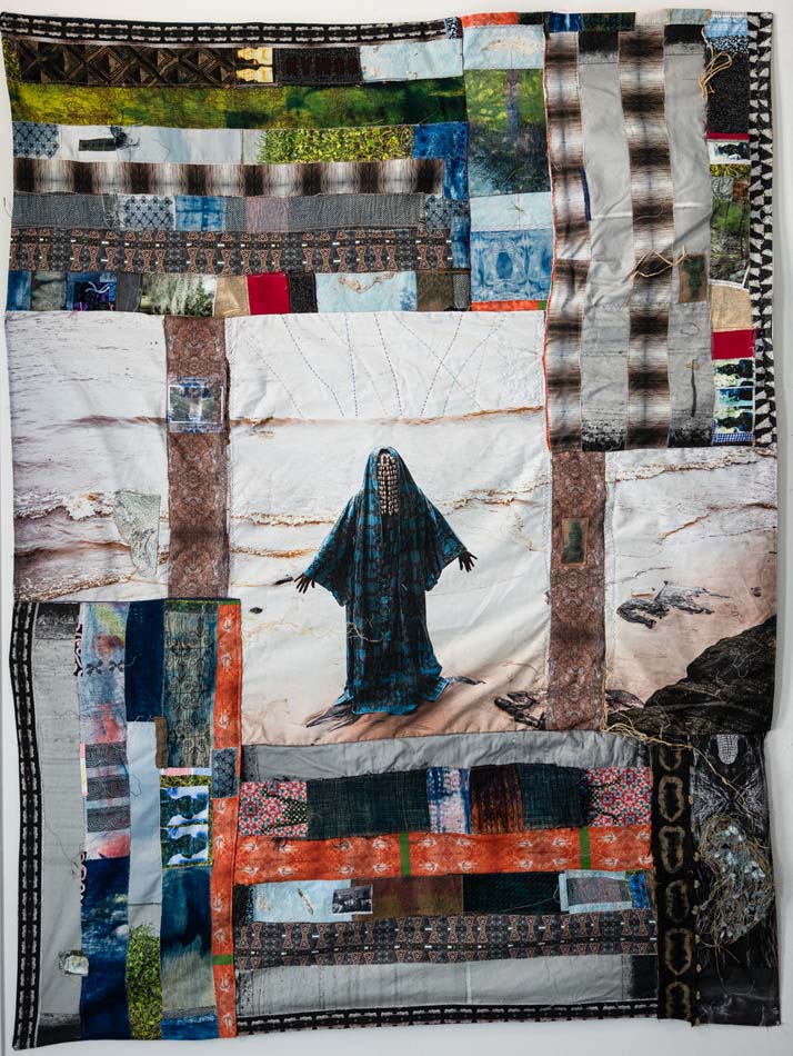 Adama Delphine Fawundu, <i>Sîmba #2: we blood, air, and water—recycled through time’s endless loop. hear the rhythm. step forward—for all who came and all to come</i>, 2025, archival pigment, cyanotypes, acrylic paint, kalaba (kaolin), and mabele chalk on cotton canvas; antique quilt from Salt Lake City, handmade banana leaf with jute pulp paper; healing herbs, Kuba cloth, and raffia from Congo, Brazil, and Sierra Leone; copper from Ghana; salt from Great Salt Lake; cobalt blue glass bottles, palm fibers, and calabash from Congo and Brazil; clay beads from Bahia; cowrie shells from Brazil, Nigeria, Congo, Sierra Leone; turkey and pheasant feathers; elements of water, wind, and sunshine from Kinshasa, Congo; Freetown, Sierra Leone; Salt Lake City, Utah; Bahia, Brazil; and Lagos, Nigeria, 