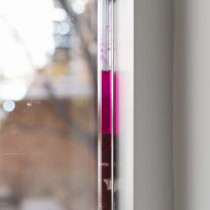 tract (aquifer) (2026), plastic polycarbonate tubes filled with the liquid dye and clusters of dye-soaked sediment sit pressure-fitted into the upper window frames of the gallery.