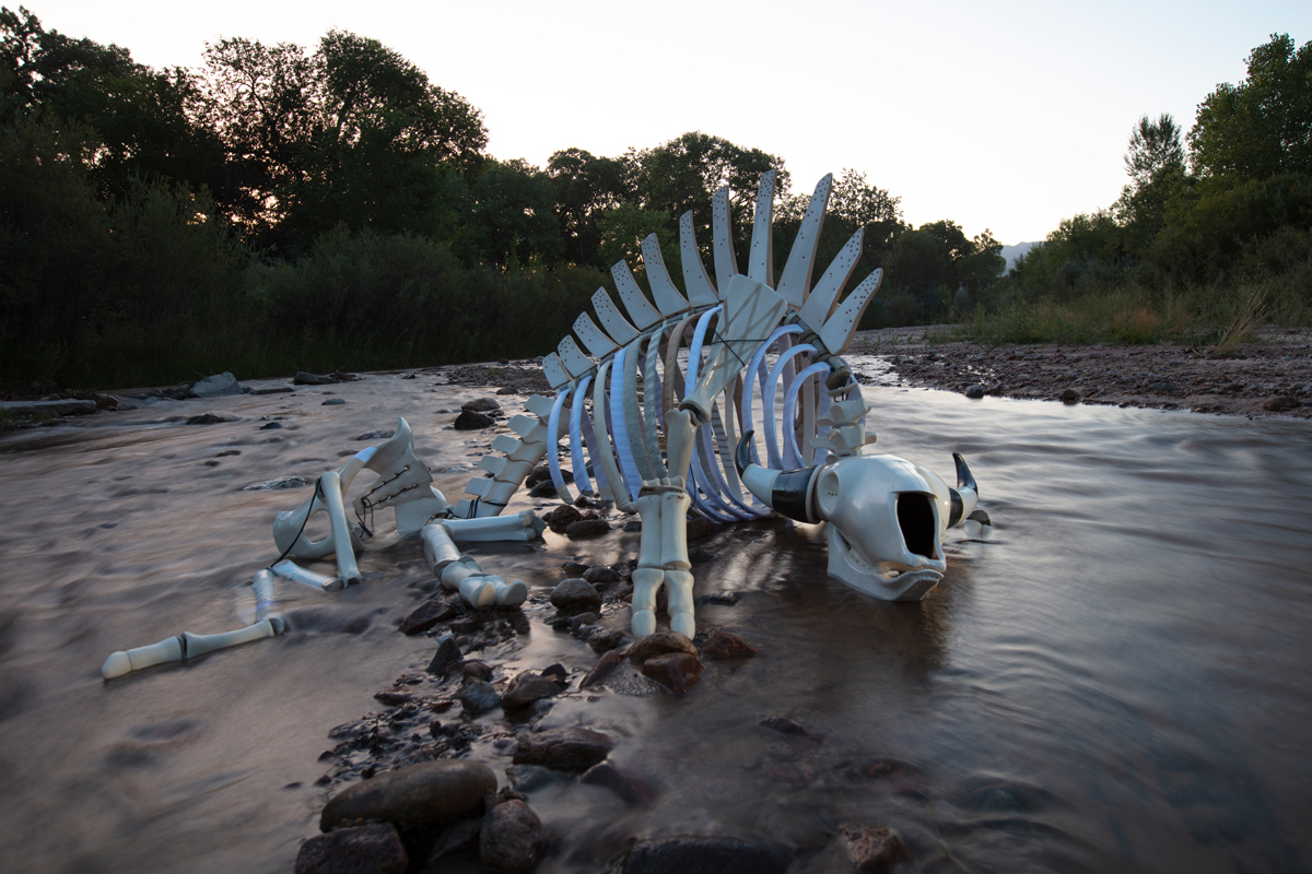 Sculpture depicting a bison skeleton in a river by Cannupa Hanska Luger.