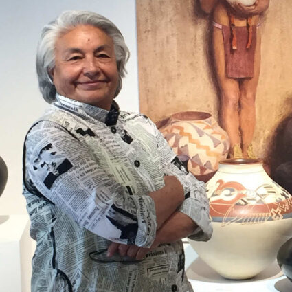 Portrait of Santa Clara Pueblo ceramicist Jody Folwell wearing a shirt with a newspaper print.